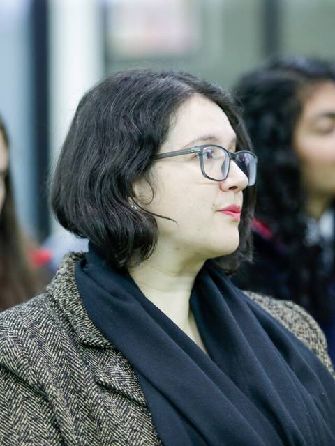 Un grupo de personas sentadas prestando atención en un evento.