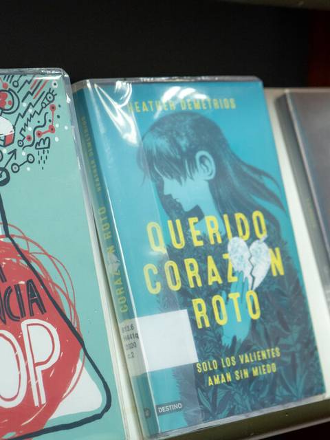 Tres libros en una estantería con títulos en español.