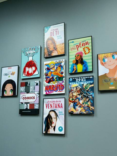 Una pared decorada con cuadros que muestran portadas de cómics y anime.