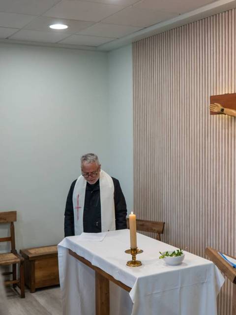 Una ceremonia religiosa en un lugar de culto con un crucifijo prominente.