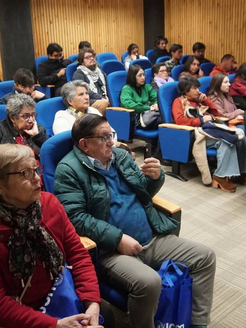 Un grupo de personas sentadas en un auditorio durante una presentación.