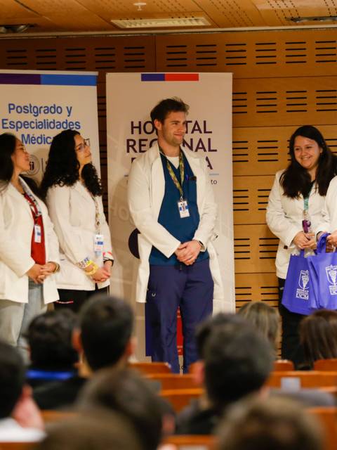 Un grupo de profesionales médicos se encuentra en una ceremonia de entrega de premios en un auditorio.