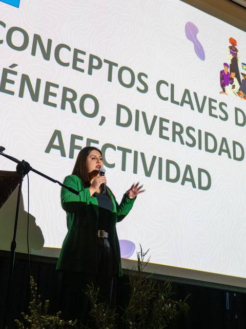 Una mujer presenta conceptos sobre género, diversidad y afectividad en una charla.