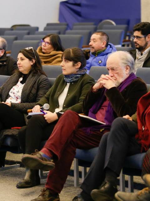 Un grupo de personas sentadas en un auditorio durante un evento o conferencia.