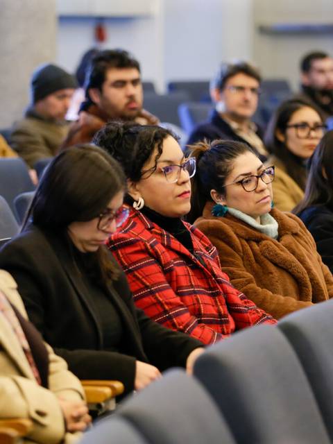 Un grupo de personas sentadas en un auditorio durante un evento.