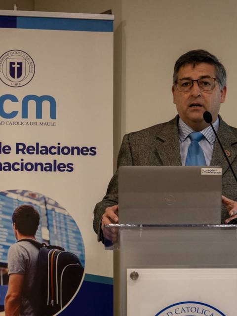 Un hombre presenta en un evento relacionado con las relaciones internacionales en una universidad.