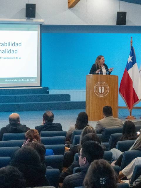 Una conferencia sobre la acción de inconstitucionalidad se lleva a cabo en un auditorio lleno de público.