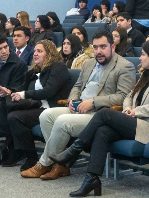 Un grupo de personas sentadas en un auditorio durante un evento.