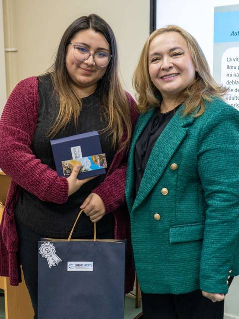 Dos mujeres sonrientes posan juntas en un evento de entrega de premios.
