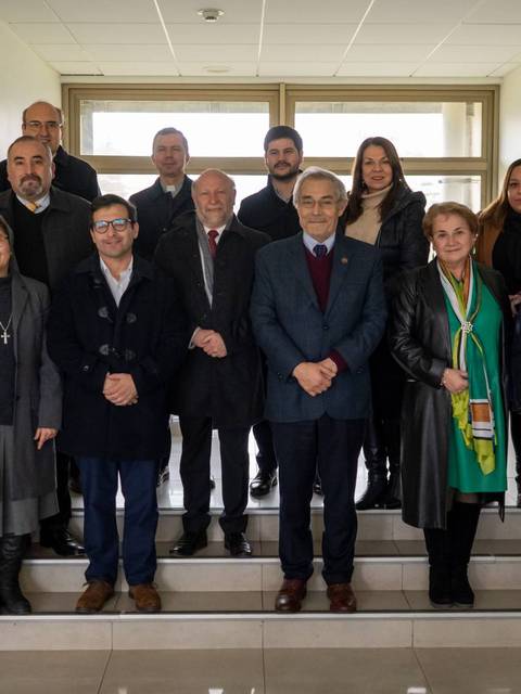 Grupo de personas posando en una escalera interior de un edificio.