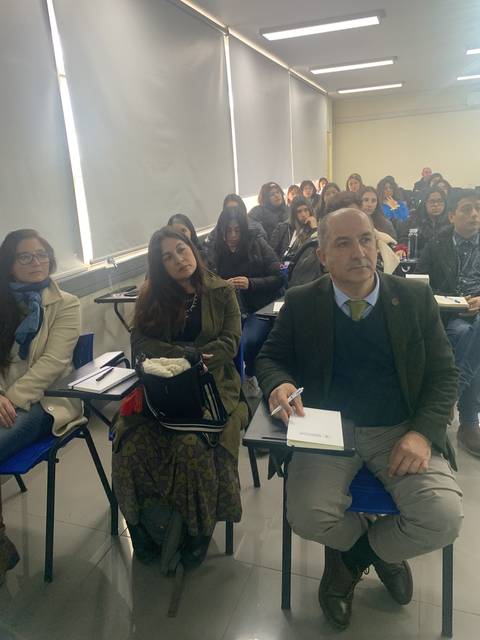 Un grupo de personas atentas en un aula durante una conferencia o clase.