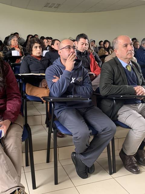 Un grupo de personas escuchando atentamente durante una conferencia en un aula.