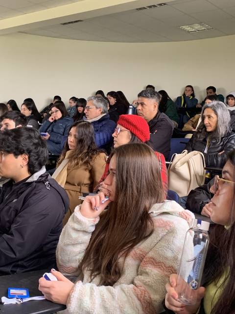 Un grupo de personas sentadas en una sala asistiendo a una charla o conferencia.