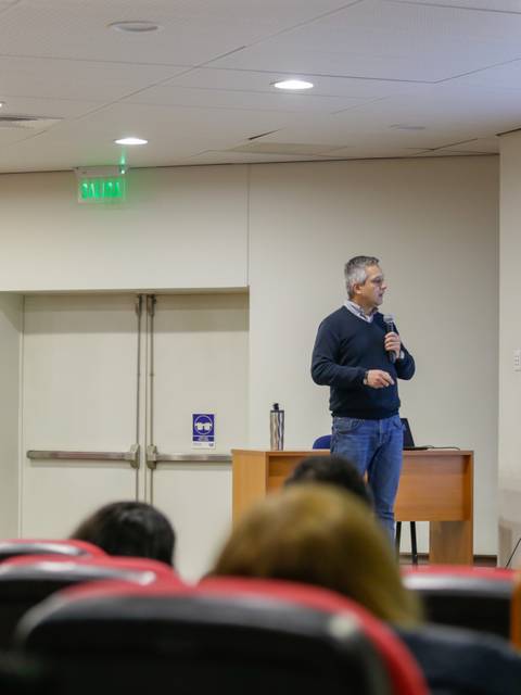 Un conferenciante presenta un tema sobre el cambio climático a un público en una sala.