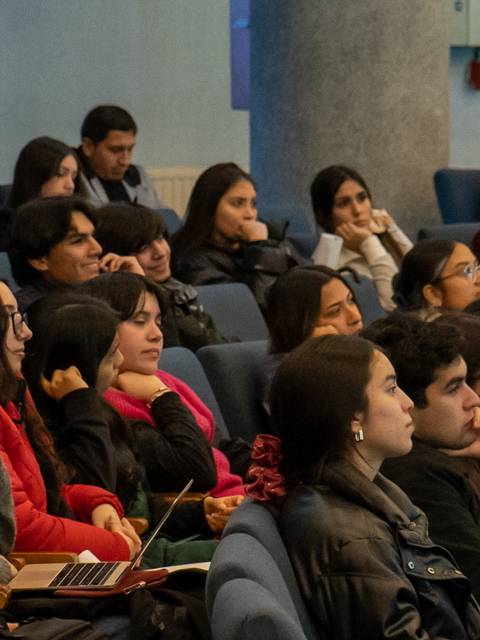 Un grupo de personas observa atentamente una presentación en un auditorio.