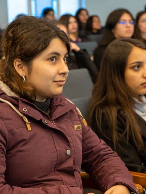 Un grupo de personas sentadas en una sala, prestando atención durante una charla o presentación.