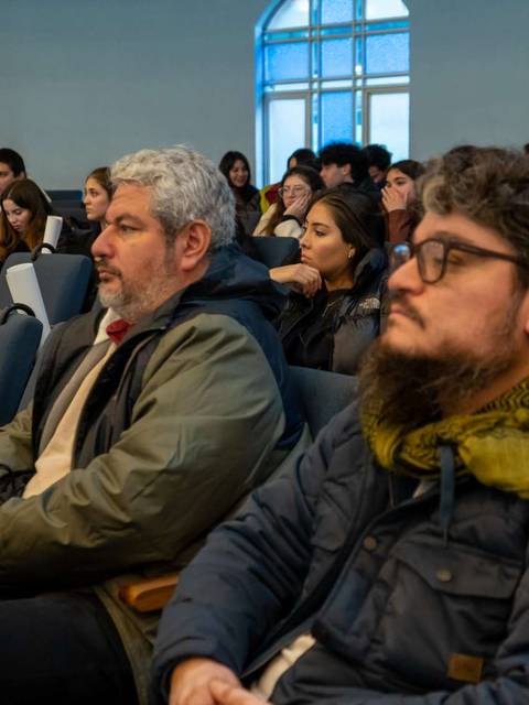 Un grupo de personas sentadas en un auditorio durante una presentación.