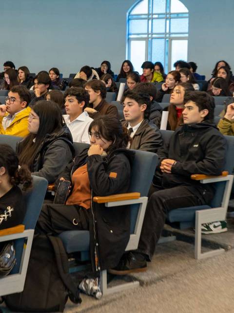 Un grupo de estudiantes sentados en un auditorio durante una charla o presentación.