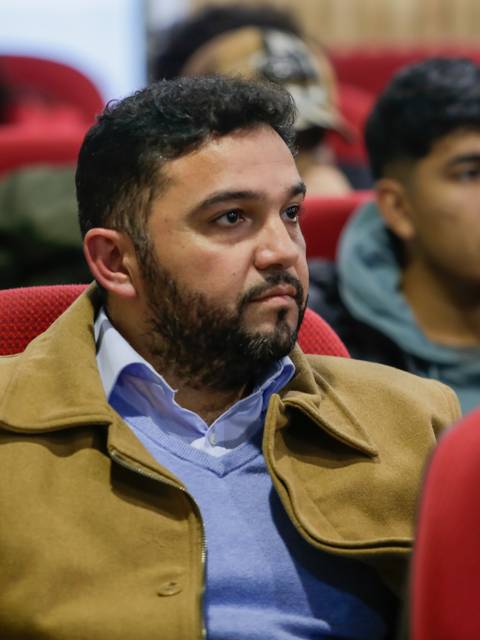 Un grupo de personas escuchando atentamente durante una presentación en un auditorio.