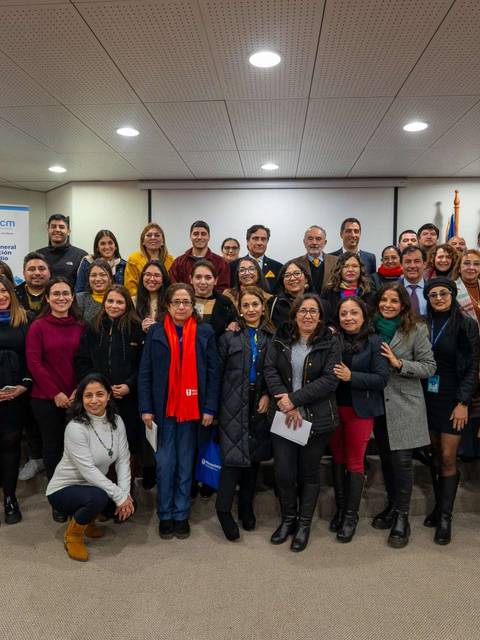 Grupo de personas sonrientes posando para una foto en un evento.