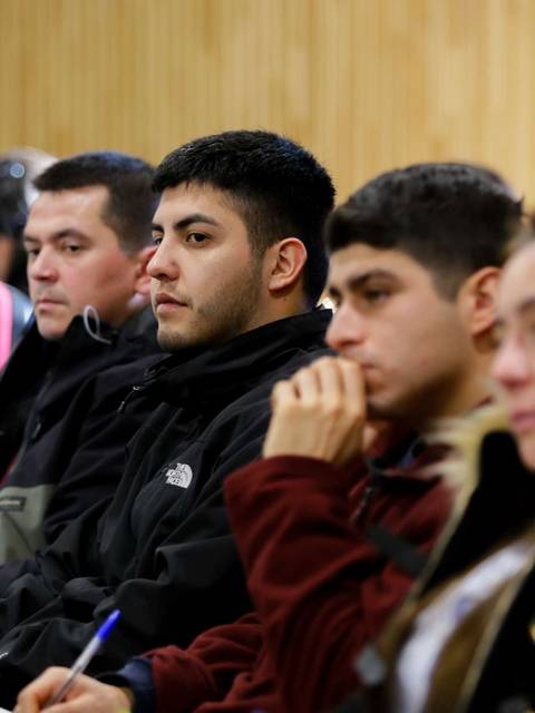 Un grupo de personas escucha atentamente en un evento.