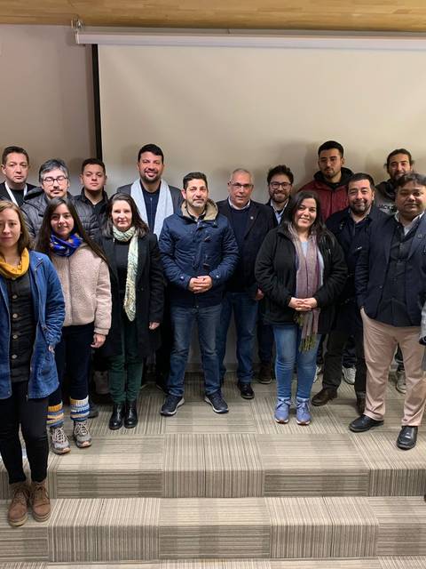 Grupo de personas posando en un evento en un auditorio.