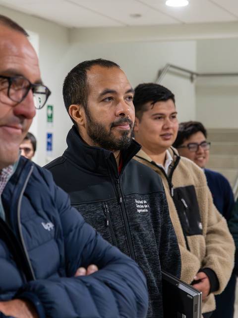 Un grupo de personas observa atentamente en un ambiente interior.