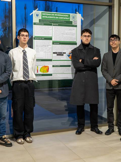 Un grupo de personas se encuentra junto a un cartel de presentación en un evento académico.