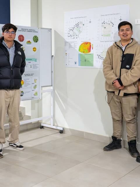 Grupo de seis personas posando frente a una presentación en un evento académico.