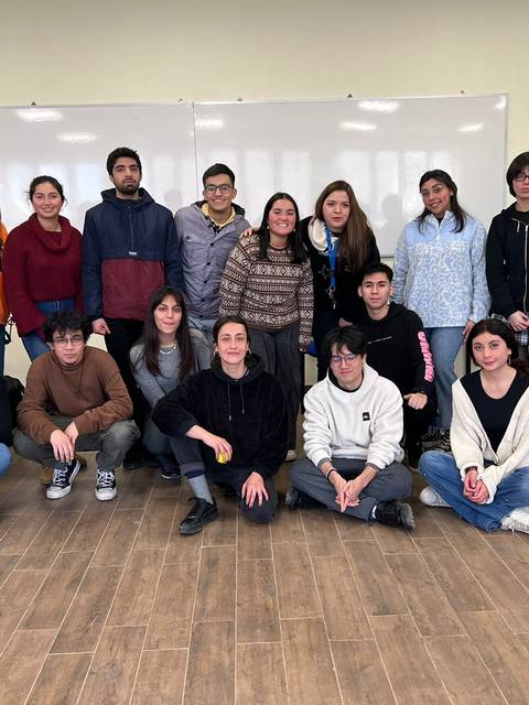 Grupo de estudiantes posando juntos en un aula.