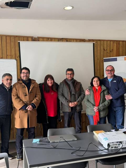 Grupo de personas posando en una sala de reunión.