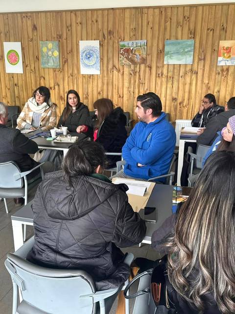 Un grupo de personas sentadas en una sala asistiendo a una charla.