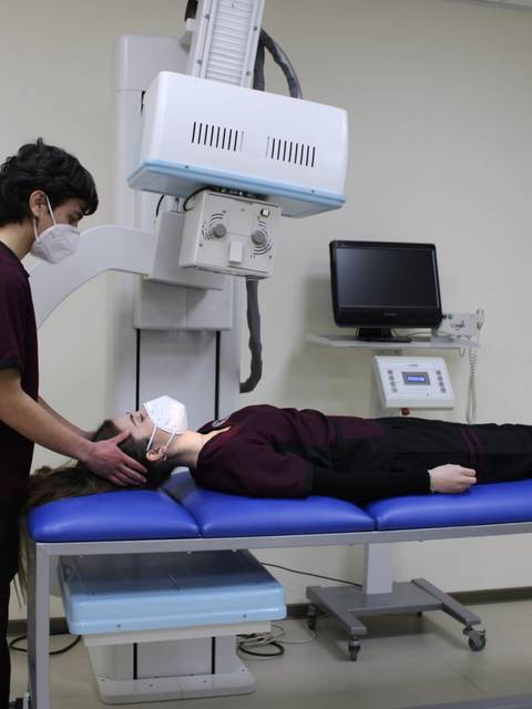Un estudiante de medicina realiza una exploración a una paciente en un entorno clínico.