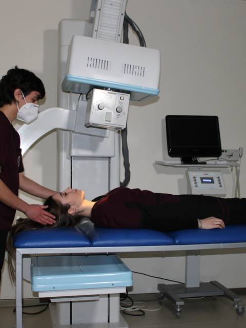 Una mujer recibe una radiografía en un entorno clínico.