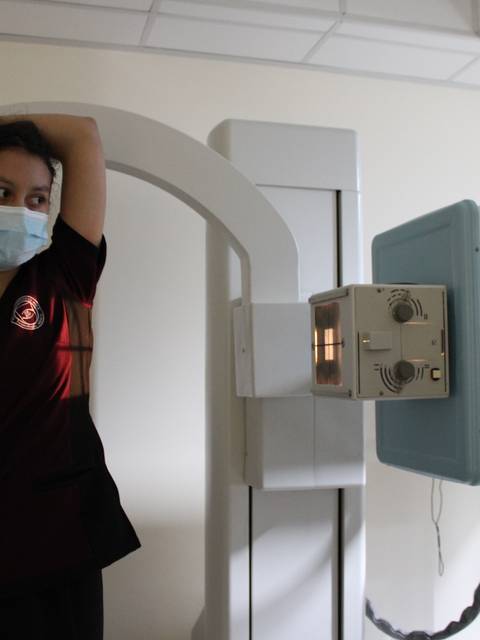 Una técnica de rayos X se prepara para realizar un examen en un equipo médico.