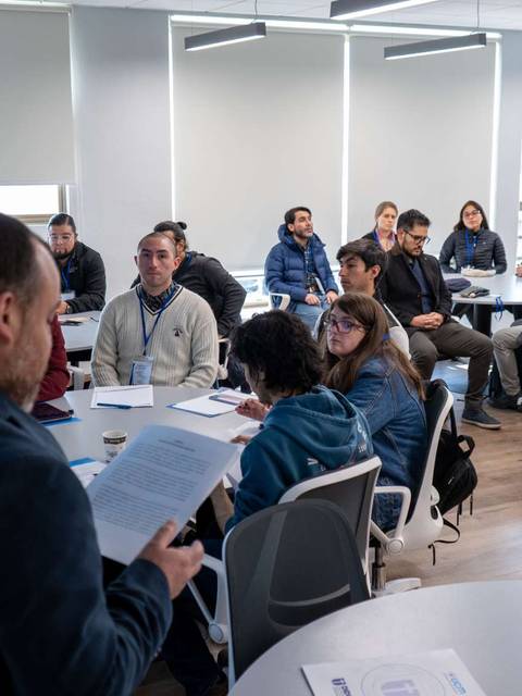 Un grupo de estudiantes asiste a una charla en un aula moderna.