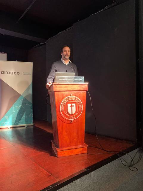 Un hombre está dando una presentación en un podio en un evento.