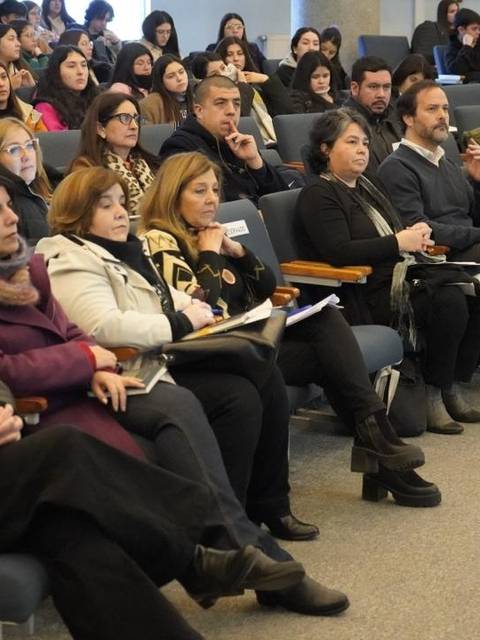Un grupo de personas sentadas en un auditorio durante una charla o presentación.