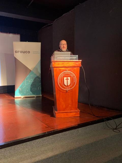 Una persona está dando una charla en un podio frente a un banner de Arauco.