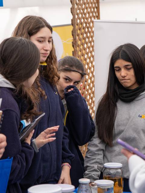 Un grupo de jóvenes se encuentra conversando en un evento o feria.