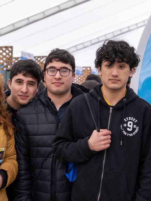 Un grupo de cinco jóvenes posando juntos en un evento educativo.