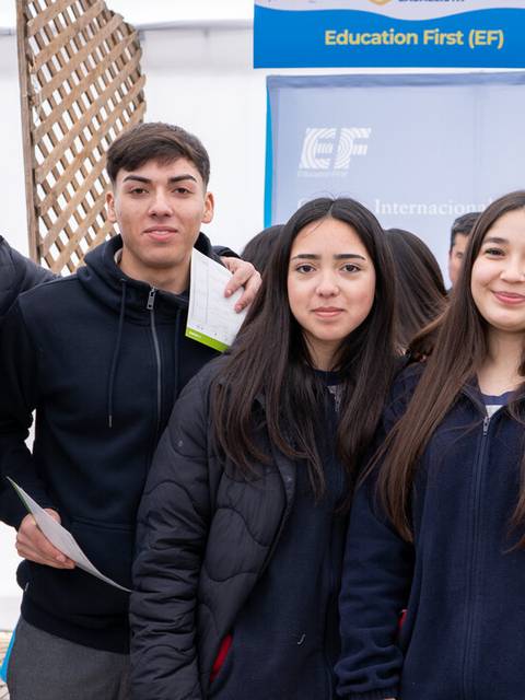 Un grupo de cinco jóvenes posando juntos en un evento educativo.