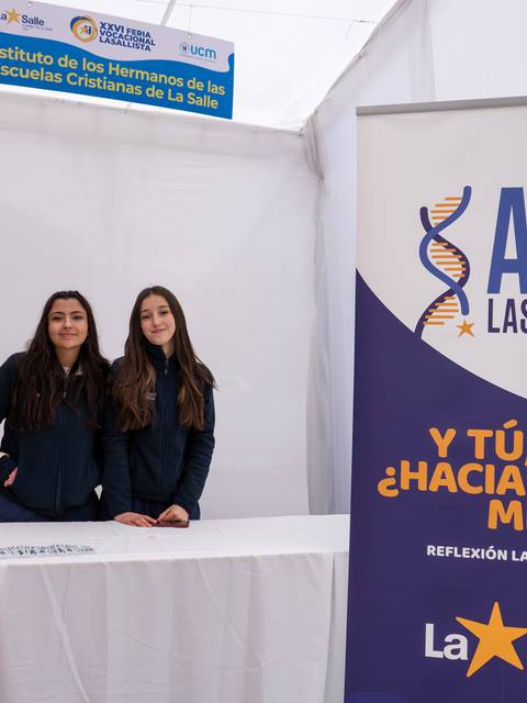 Dos chicas posan en un stand del Instituto de los Hermanos de las Escuelas Cristianas de La Salle.