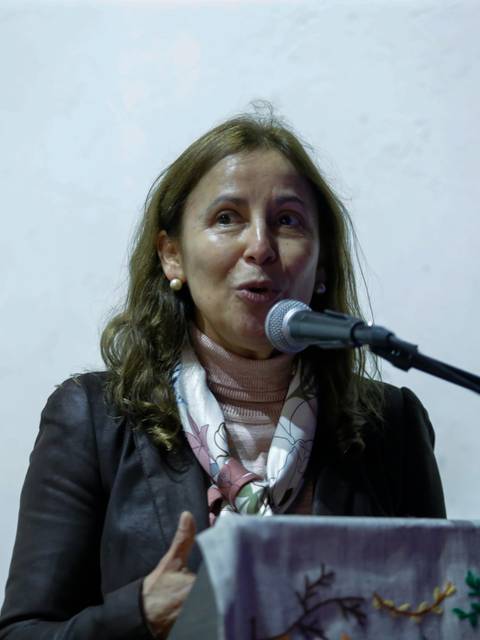 Una mujer habla en un micrófono durante un evento.