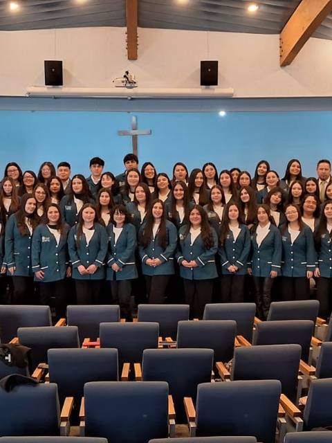 Grupo de personas posando juntas en un auditorio.