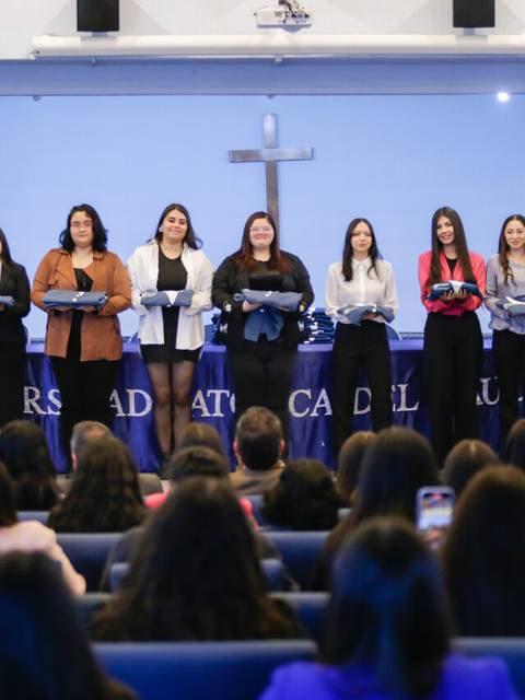 Un grupo de estudiantes en un evento de entrega de reconocimientos en una universidad.
