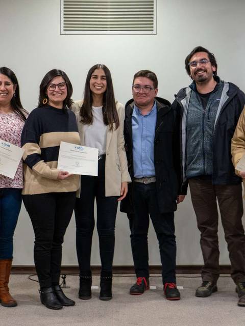 Un grupo de personas sonrientes sostiene certificados en un evento de entrega de premios.