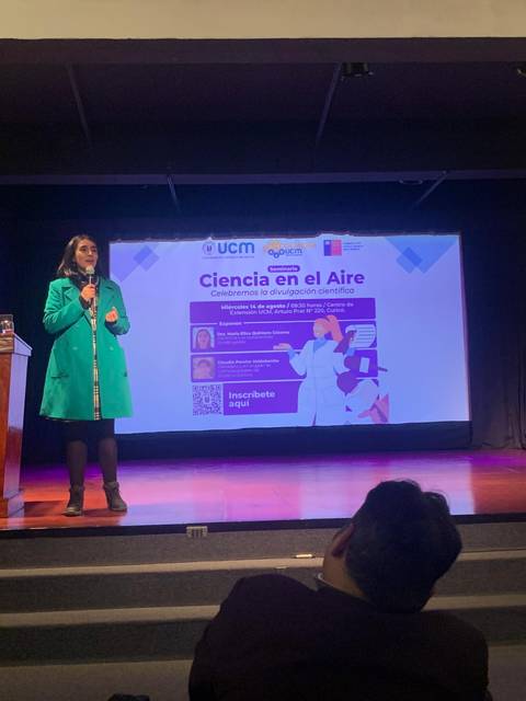 Una mujer habla en un escenario durante un evento llamado 'Ciencia en el Aire'.