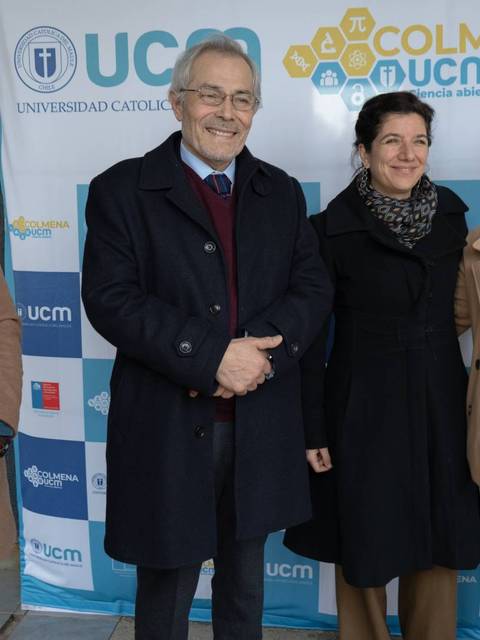 Un grupo de personas posando frente a un fondo con el logotipo de la Universidad Católica y el evento Colmena UCM.