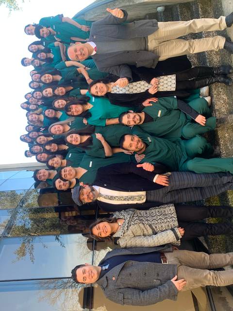 Un grupo grande de personas posando juntas frente a un edificio.